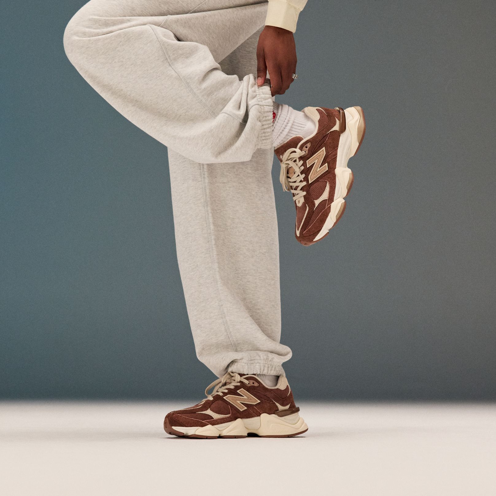 Pile of New Balance sneakers on beige background